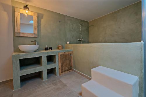 y baño con lavabo y tocador con espejo. en Casa Sofia Apt#1, en Spílion