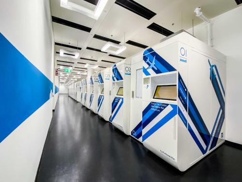 una fila de lavadoras y secadoras en una habitación en Resting Pods - Zzzleepandgo Wien Airport en Schwechat