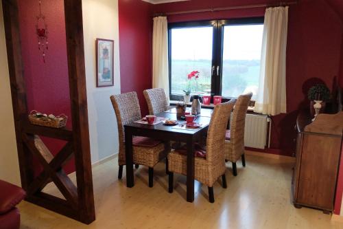 PommerbyにあるFerienwohnung Gartenblickのテーブルと椅子と窓のあるダイニングルーム