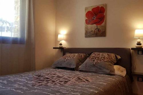 a bedroom with a bed with two pillows and a painting at Precioso apartamento en El Tarter frente a pistas in El Tarter