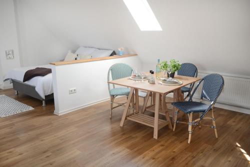 einem Esstisch mit 4 Stühlen und einem Bett in der Unterkunft Ferienwohnungen im HOF68 in Münster