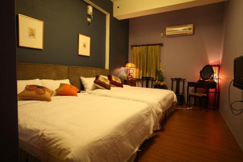 1 dormitorio con 2 camas y TV en Heart Stay, en Hualien City