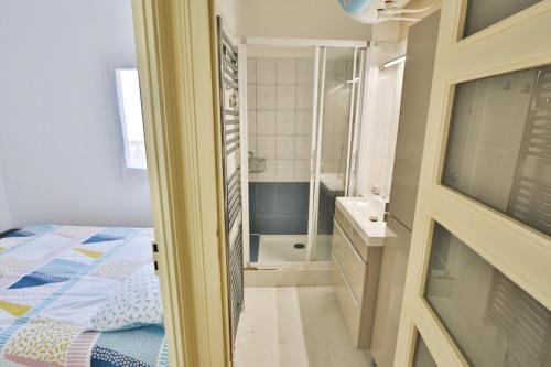 a bedroom with a bed and a bathroom with a shower at APPARTEMENT 1 à 9 personnes Hagetmau coeur de ville in Hagetmau