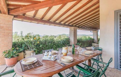 einen Holztisch mit Tellern und Gläsern auf einer Terrasse in der Unterkunft Casale Cacciata Grande Elisa in Pescia Romana