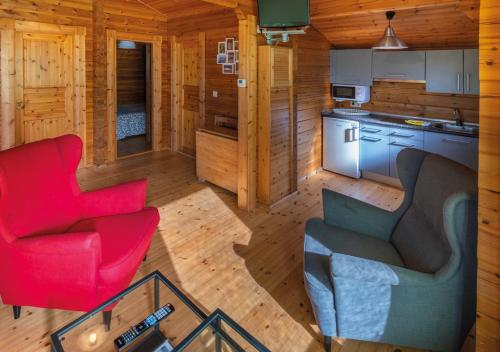 una cabaña de madera con vistas a una sala de estar y una cocina. en Cabañas El Ruso en Galende