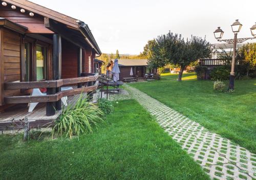 a house with a brick path next to a yard at Cabañas El Ruso in Galende