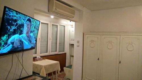a living room with a flat screen tv on a wall at One Bedroom Apartment French Embassy in Bucharest