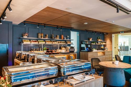 a restaurant with blue walls and a counter with tables at Radisson Hotel Plovdiv in Plovdiv