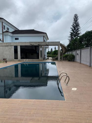 a swimming pool in front of a house at Gordonsville Escape Boutique Hotel in Port Harcourt