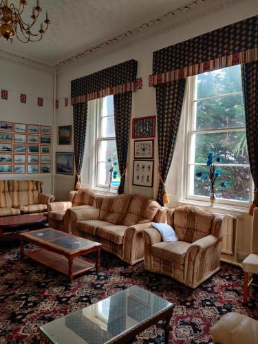 a living room with couches and a table at Inglewood Palm Hotel, Abbey Sands Torquay in Torquay