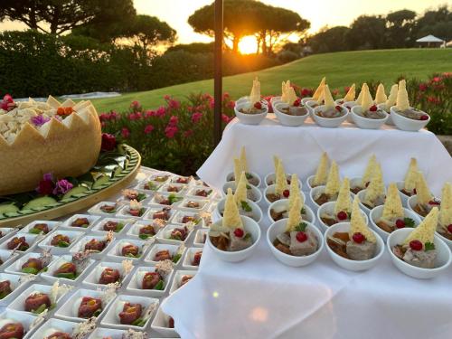 a buffet of appetizers on a table with the sunset at Gallia Palace Hotel - Relais & Châteaux in Punta Ala
