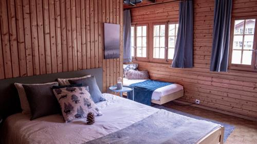 ein Schlafzimmer mit einem Bett in einer Holzhütte in der Unterkunft Relais des Mélèzes in Vissoie