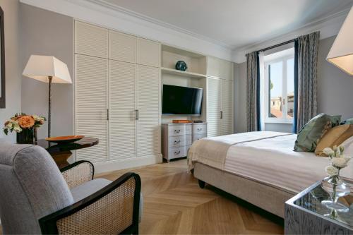 a bedroom with a bed and a tv and a couch at Rocco Forte Hotel De Russie in Rome