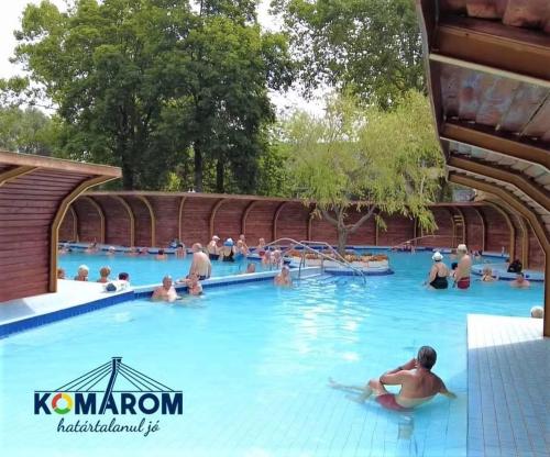 a group of people in the water at a swimming pool at Hét Vezér Apartmanhotel in Komárom