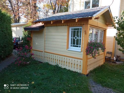 a small shed with a window and a roof at Jurmala`s Center Mini House in Jūrmala