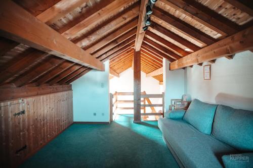 a living room with a couch and a wooden ceiling at La Trientale 10 pers -Malmedy in Xhoffraix