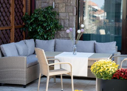 a patio with a couch and a table and chairs at Central Park Home Spa in Arandjelovac