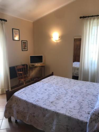 a bedroom with a bed and a desk and a television at Affittacamere Cerisola 2003 in Zoagli