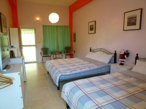 a hotel room with two beds and a television at 悦來民宿 台東縣民宿334號 in Taiping