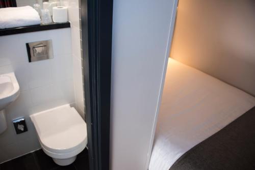 
a white toilet sitting next to a white sink at Point A Hotel London Westminster in London
