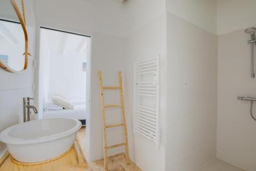 a bathroom with a ladder next to a white bath tub at À 550m de la plage, maison pour 4 in Saint-Martin-de-Ré