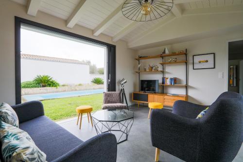 un salon avec deux canapés et une grande fenêtre dans l'établissement Belle maison pour un sejour a 10 personnes au coeur de l'ile de Re, au Bois-Plage-en-Ré