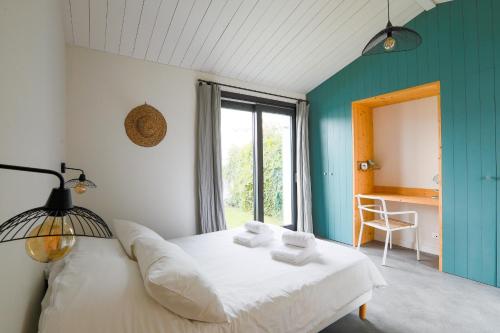 a bedroom with a white bed and a window at Belle maison pour un sejour a 10 personnes au coeur de l'ile de Re in Le Bois-Plage-en-Ré