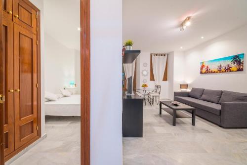un soggiorno con divano e letto di Apartamentos Granata a Granada