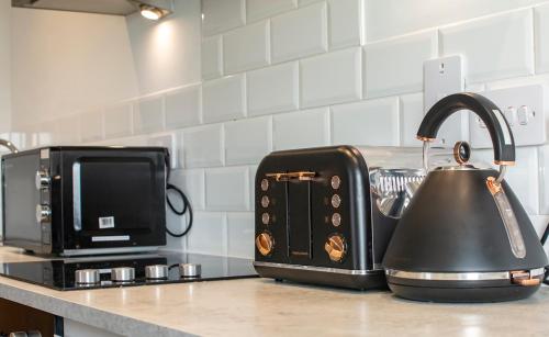 a tea kettle sitting next to a toaster on a kitchen counter at Modern Flat Minutes Walk From Restaurants - Bars - Clubs - Beach in Bournemouth