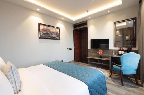 a bedroom with a bed and a desk and a chair at WelcomHeritage Elysium Resort & Spa in Shimla