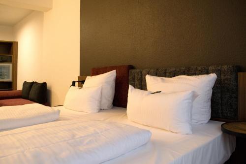 a bedroom with a bed with white pillows at Hotel am Schlosstheater in Fulda
