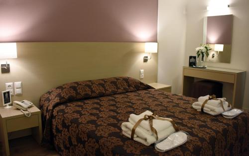 une chambre d'hôtel avec un lit et des serviettes. dans l'établissement Dionisos Hotel, à Larissa