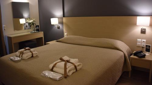 a hotel room with a bed with towels on it at Dionisos Hotel in Larisa