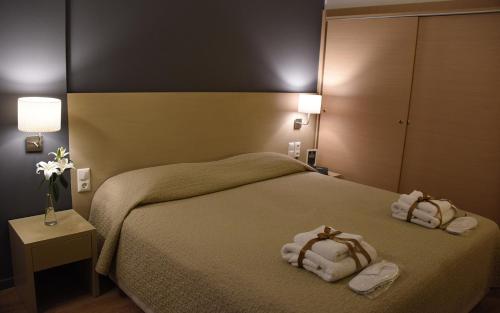 a hotel room with a bed with towels on it at Dionisos Hotel in Larisa