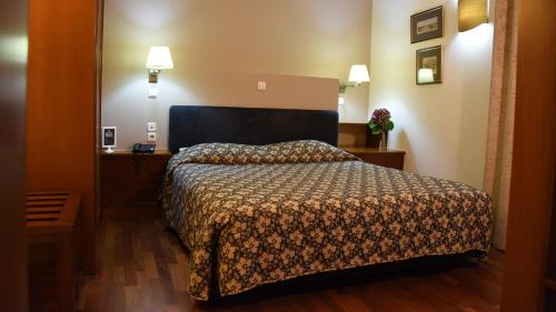 a hotel room with a bed with a comforter at Dionisos Hotel in Larisa