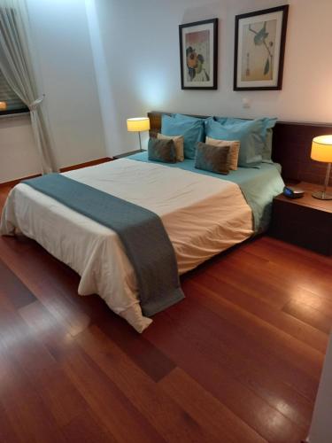 a bedroom with a large bed with a wooden floor at La Suite Calypso in Luz
