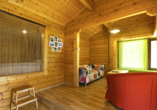 a log cabin with a chair and a window at Cabañas El Ruso in Galende