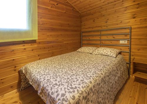 a bedroom with a bed in a wooden cabin at Cabañas El Ruso in Galende