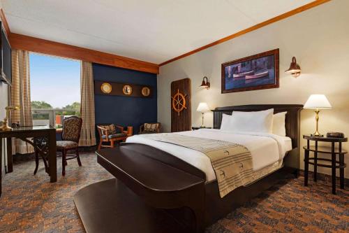 una camera d'albergo con un grande letto e una scrivania di Ramada by Wyndham Fredericton a Fredericton