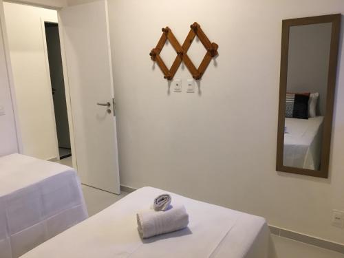 a white room with a bed and a mirror at Privê Portal do Sol in Porto De Galinhas