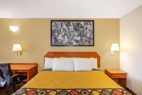 a hotel room with a bed and a desk and a bed sidx sidx at Super 8 by Wyndham North Palm Beach in North Palm Beach