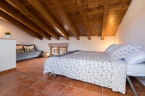 a bedroom with a bed and a couch at El Rincón de Braulieta in Nogueruelas