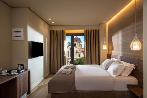 a bedroom with a large bed and a window at Metropole Urban Hotel in Heraklio Town