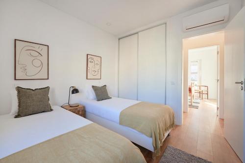 Duas camas num quarto branco com um corredor em Deluxe Apt at Amazing Prime Location, By TimeCooler em Lisboa
