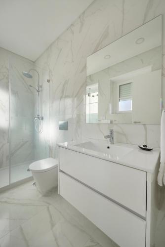 a white bathroom with a sink and a toilet at Deluxe Apt at Amazing Prime Location, By TimeCooler in Lisbon