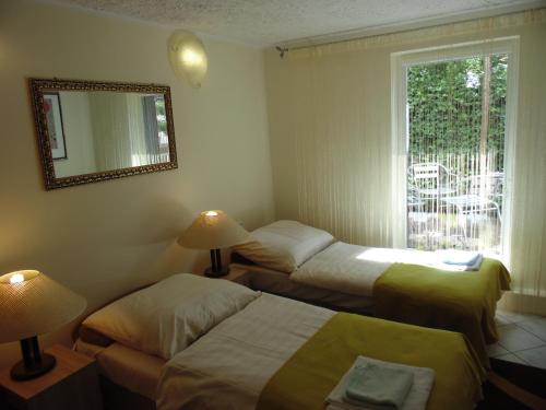 two beds in a room with a mirror and a window at Apartament "Cudowna Wyspa" in Świnoujście