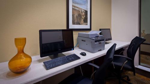 an office cubicle with a desk with a computer and a printer at Best Western Plus Spring Inn & Suites in Spring