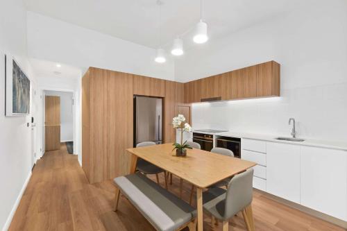 a kitchen and dining room with a wooden table and chairs at Club Wyndham Flynns Beach, Trademark Collection by Wyndham in Port Macquarie