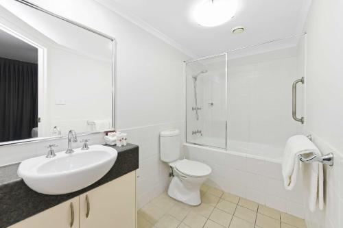 a bathroom with a sink and a toilet and a shower at Club Wyndham Flynns Beach, Trademark Collection by Wyndham in Port Macquarie