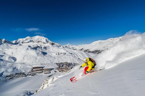 a person is skiing down a snow covered mountain at Hôtel VoulezVous by Les Etincelles in Tignes